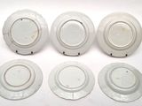 six white porcelain plates with different designs on them on a white surface