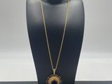 a black mannequin with a gold necklace on it