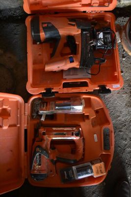 deux outils orange dans un coffret posé par terre