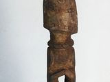 a wooden sculpture that is standing on a stand