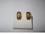 a pair of gold toned earrings on a white surface