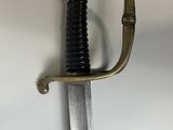 a close up of a sword on a white surface