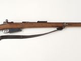un vieux fusil avec un canon en bois sur une surface blanche