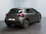 the back of a grey car is parked in a large room