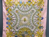 a pink scarf with gold and blue designs on it