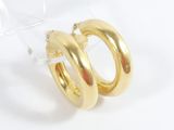 pair of gold toned hoop earrings on clear acrylic stand