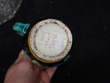 a person holding a cup with a lid on a table