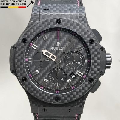 un gros plan d'une montre noire avec un bracelet rose