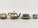 un service à thé en métal argenté composé de quatre tasses et soucoupes