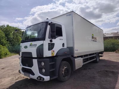 un camion garé sur un terrain en terre battue