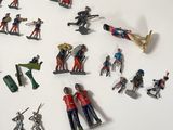 many toy soldiers that are on a white surface