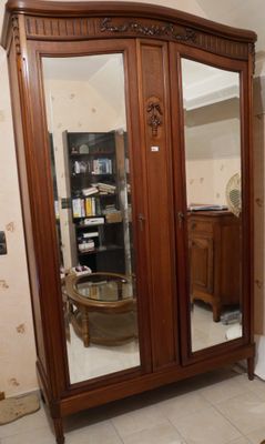 une grande armoire en bois munie d'un miroir