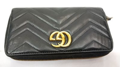 un gros plan d'un sac à main noir orné d'un logo doré