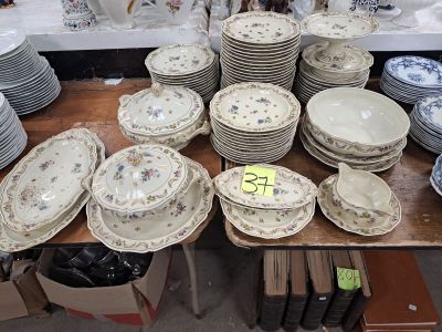de nombreuses assiettes et bols posés sur une table, accompagnés d'une étiquette indiquant le prix