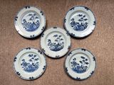 four blue and white plates with flowers on them on a table