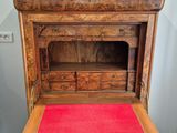 a wooden desk with a marble top and a red rug