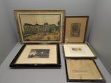 trois photos encadrées représentant des bâtiments, posées sur une table devant un mur