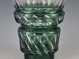 a green glass vase sitting on top of a table
