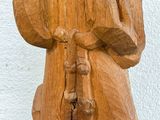 a wooden statue of a man with a hat and a cane