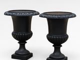 pair of black urns on pedestals on a white background