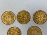 quatre pièces d'or présentant des motifs différents, posées sur un fond blanc