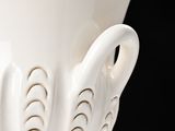 a white vase that is sitting on a table