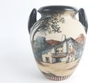 a vase with a painting on it on a white surface