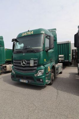 Plusieurs camions verts sont garés les uns à côté des autres sur un parking.