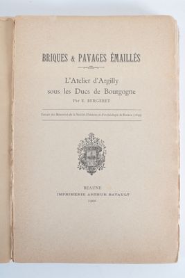 un livre ouvert sur lequel figure un blason