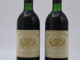 two bottles of wine sitting next to each other on a white surface