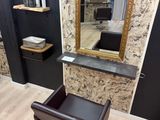 a chair and a mirror in a room with black walls