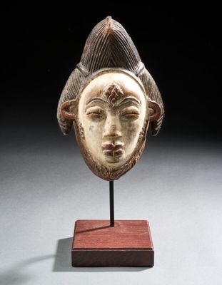 un gros plan sur une sculpture en bois représentant le visage d'une femme