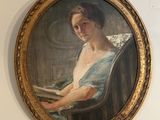 un tableau représentant une femme en train de lire un livre, accroché au mur