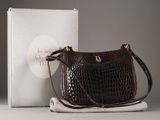 un sac à main marron posé à côté d'une boîte sur une table