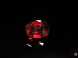 a close up of a red diamond on a black surface