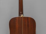 a close up of an acoustic guitar hanging on a wall