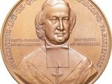 une image représentant une médaille de bronze sur laquelle figure le portrait d'un prêtre