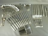 many forks and spoons laid out on a table