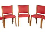 quatre fauteuils en cuir rouge aux pieds et dossiers en bois, sur fond blanc