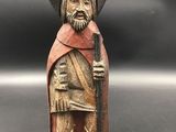 a close up of a figurine of a man wearing a hat and holding a sword