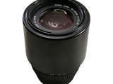 a black camera lens sitting on a white surface