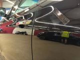 a black car parked in a garage next to a red wall