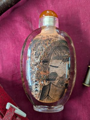 une bouteille en verre avec une image dessus, à côté d'une paire de ciseaux
