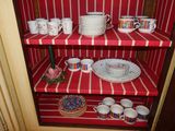 a red shelf with dishes and cups on it