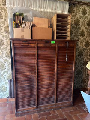 a wooden cabinet with many boxes on top of it