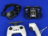 deux télécommandes et une manette posées sur une surface bleue