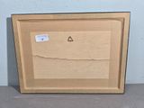 an empty picture frame with a piece of wood on it