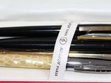 three pens in a box with a ribbon around them