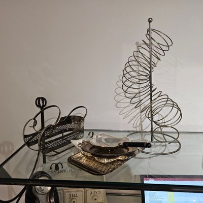 une table en verre sur laquelle sont posés un ordinateur portable et un sapin de Noël en fil de fer