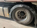a semi truck with a flat tire parked in front of a building